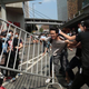 A group of unidentified men pulls a pro-democracy protester from a barricade.